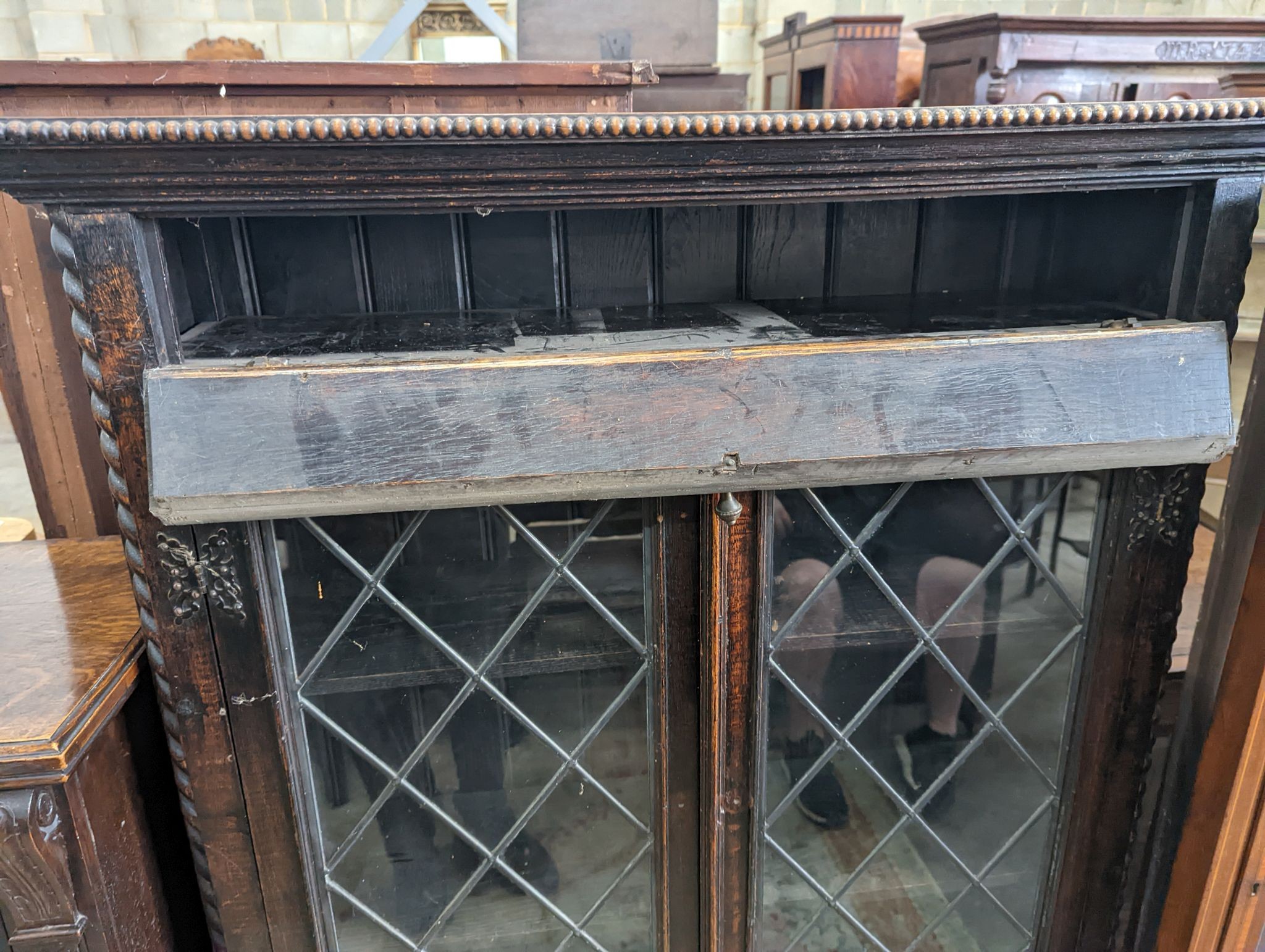 An early 20th century glazed oak two door bookcase, length 99cm, depth 29cm, height 150cm